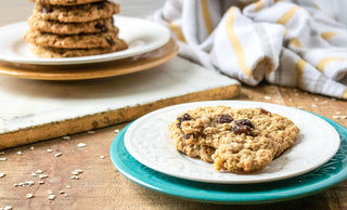 delicious hot out of the oven oatmeal raisin cookie on a plate with more cookies stacked in the background recipe image 