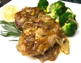One Skillet Lemon-Rosemary Chicken Thighs with Broccoli  with delicious garnish on a white plate 