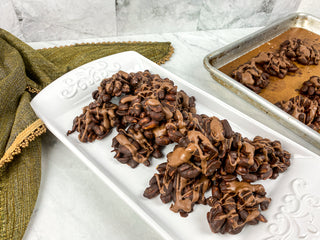 fresh chocolate peanut clusters on a white plate 