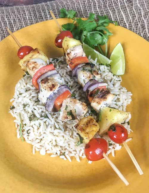 The Best Swordfish & Pineapple Kabobs recipe image with beautiful kabobs full of color on a bed of rice 